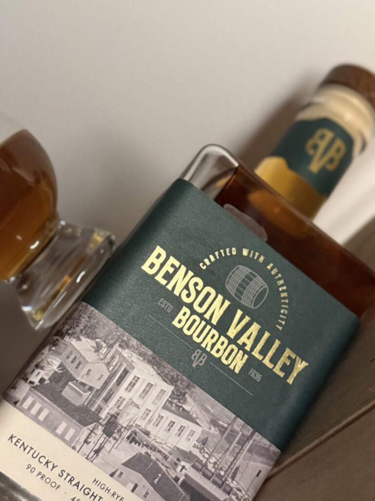 Benson Valley High Rye Bourbon 90 Proof lying angled with glencairn on top