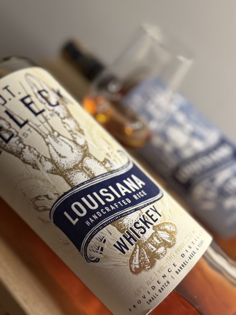 JT Meleck 100% rice whiskey 96 proof and 118 proof bottles close up with one blurred