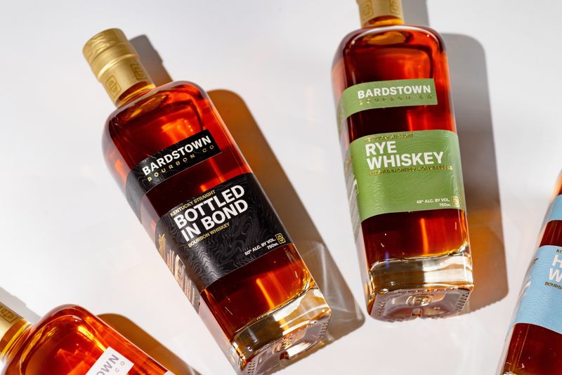 Closeup of bardstown bottled in bond bourbon and rye with newly redesigned labels arranged in arc.