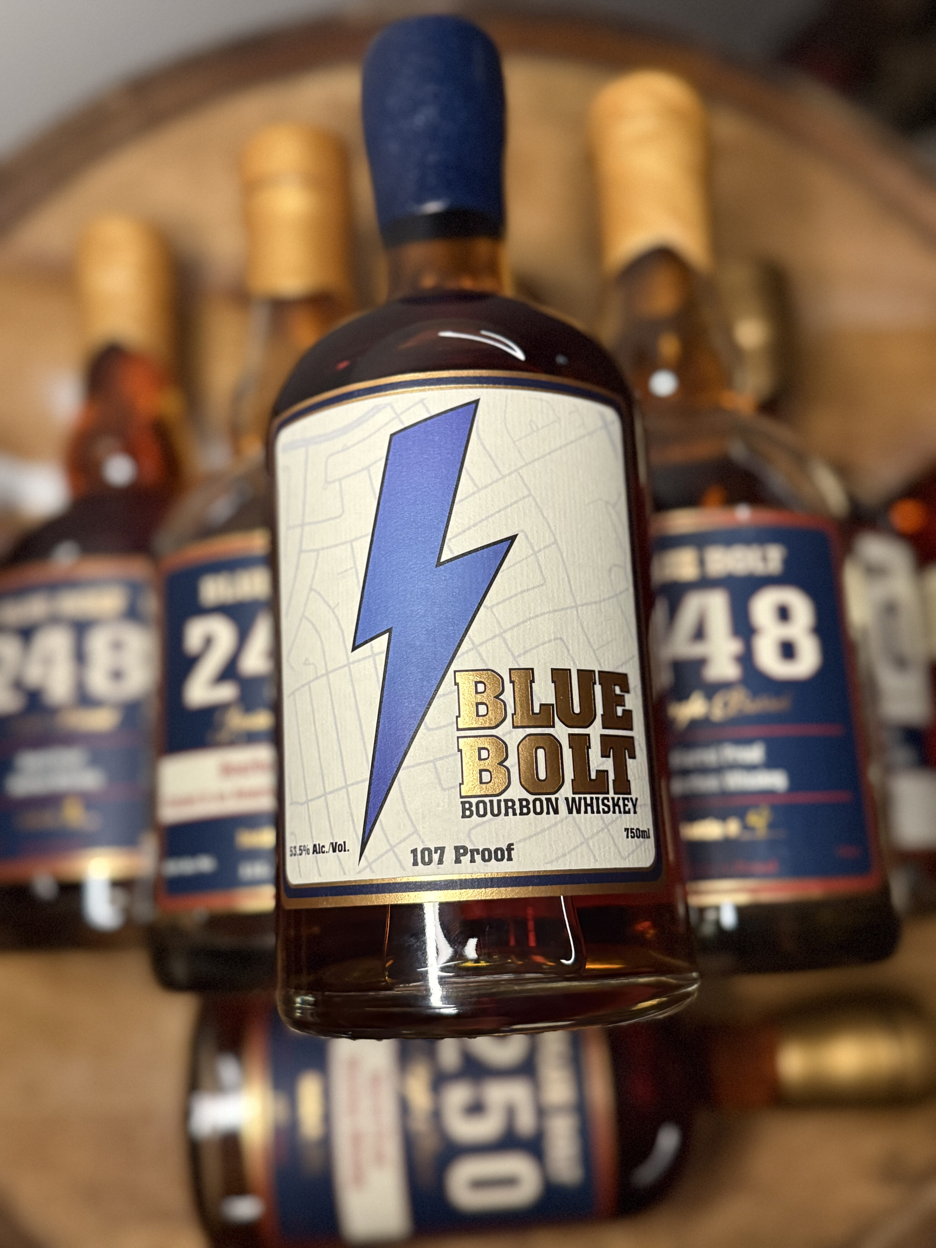 Blue Bolt 107 Proof Small Batch Bourbon stacked on past single barrels