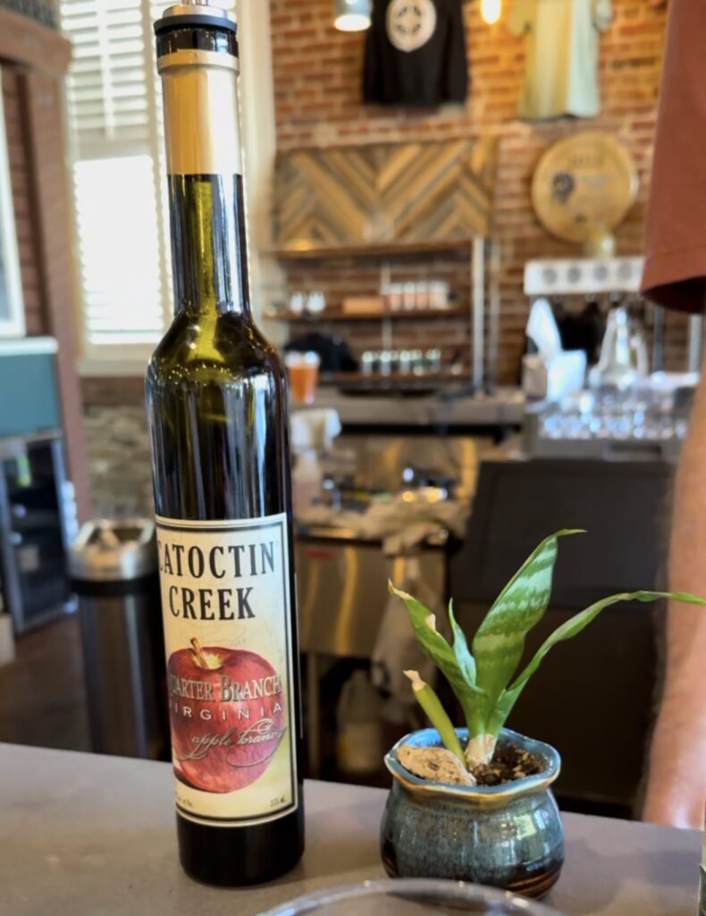 Catoctin creek apple brandy sitting on bar beside succulent