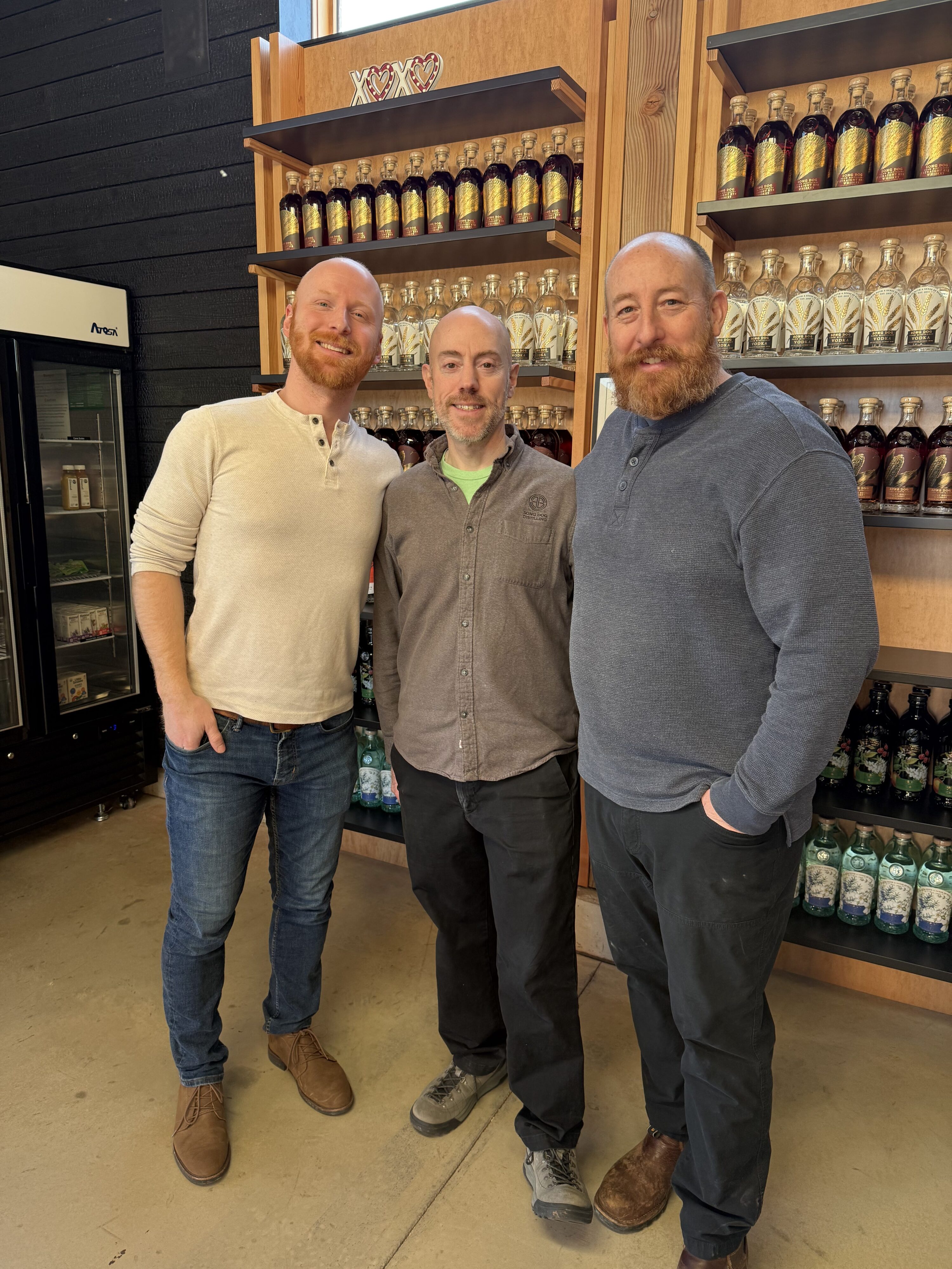 (Left to Right) E.S. Pope, Owner David Harris, and Head Distiller Kristian Naslund in front of gift shelves