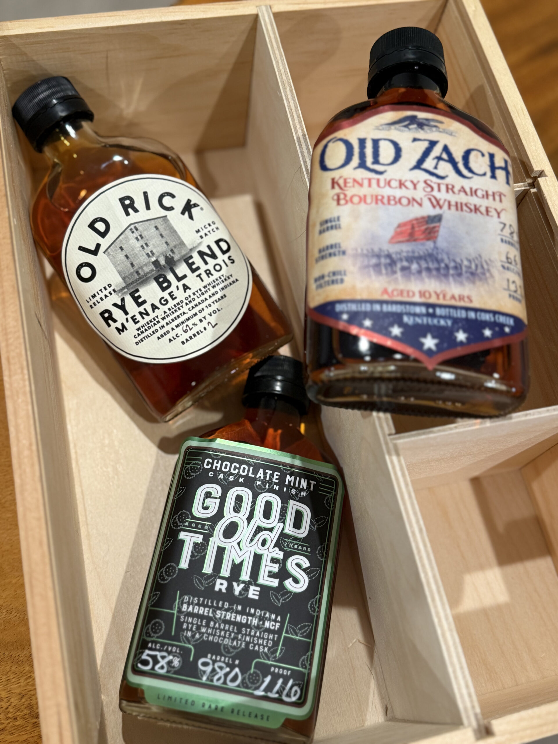 Good Times Chocolate Mint Cask Finished Rye 116 Proof and Old Rick Menage A Trois Rye Blend 124 Proof visible with blurred sample from Old Zach on box