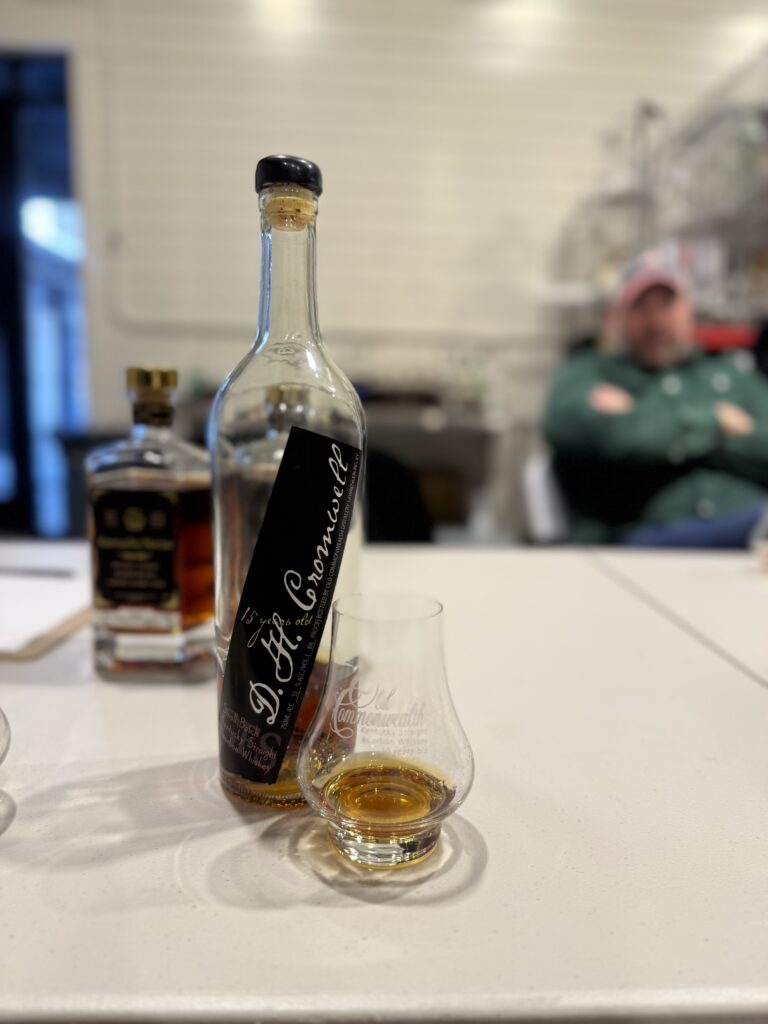 Old Commonwealth D.H. Cromwell by glass with blurred Andrew English behind it