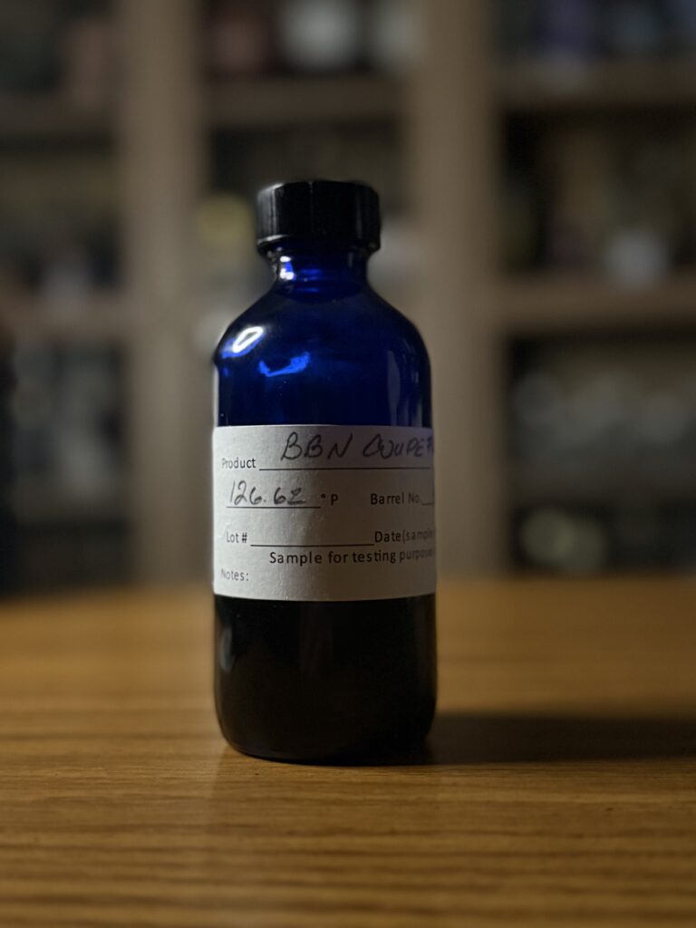 Open Road bourbon coupe #6 sample on desk in front of whiskey collection