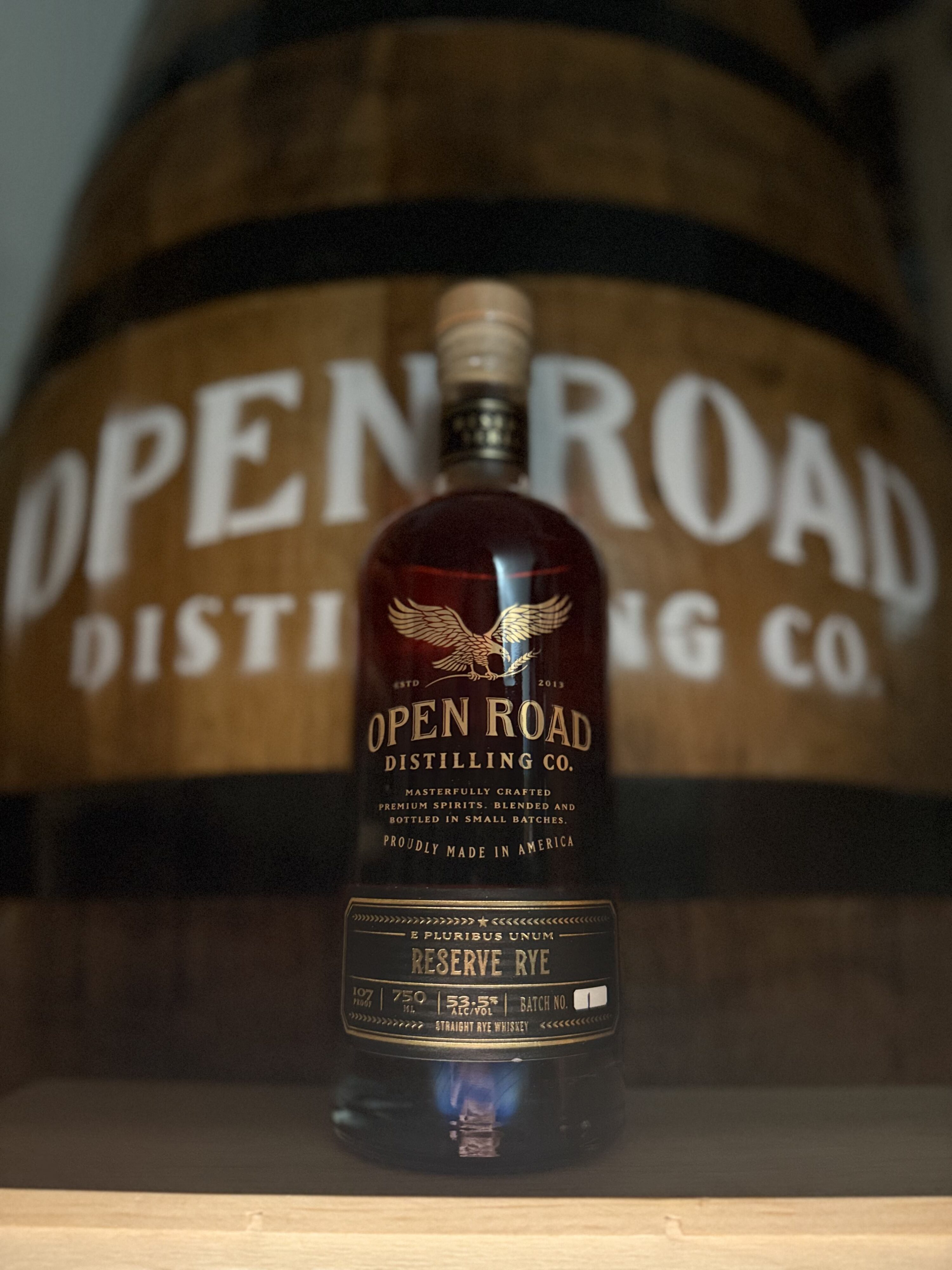 Open Road Reserve Rye out of box standing in front of Open Road whiskey barrel