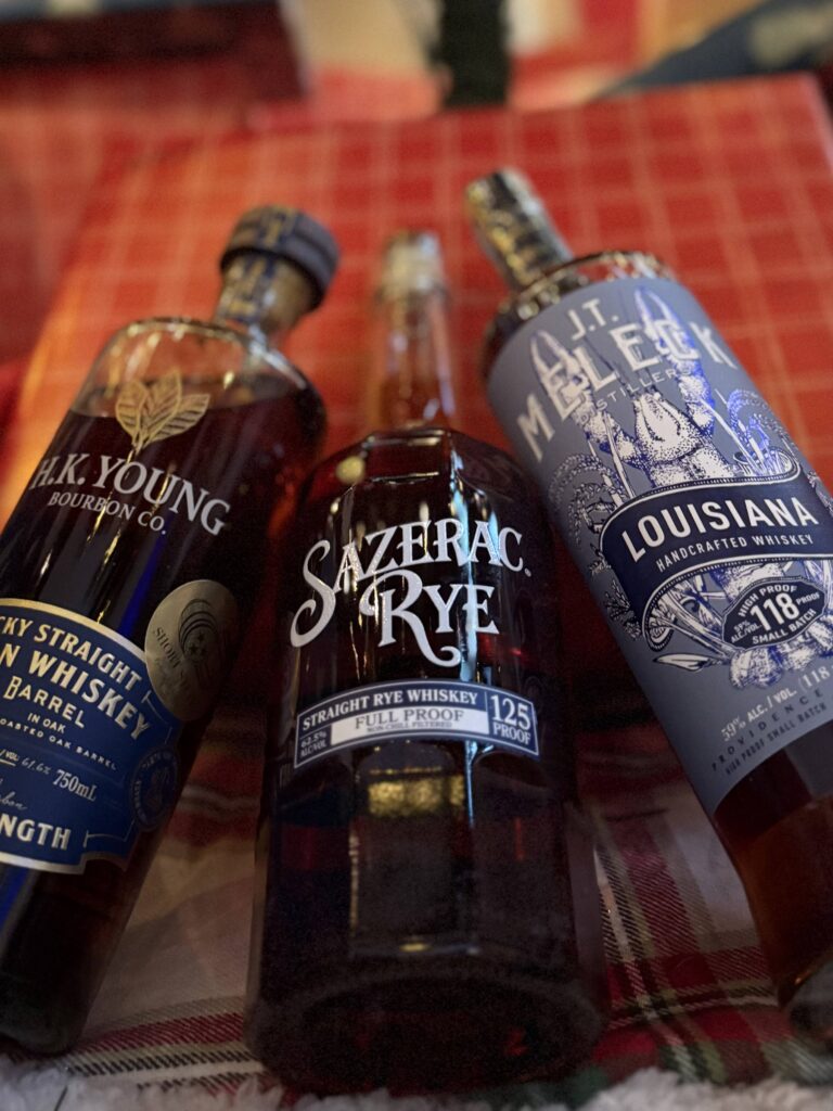 Sazerac Full Proof Rye lying with HK Young and JT Meleck bottles on red present close up