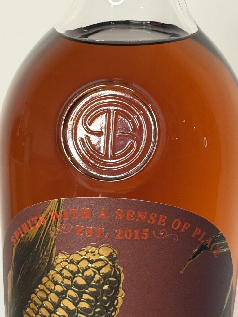 Song Dog bourbon closeup of inset glass logo on bottle