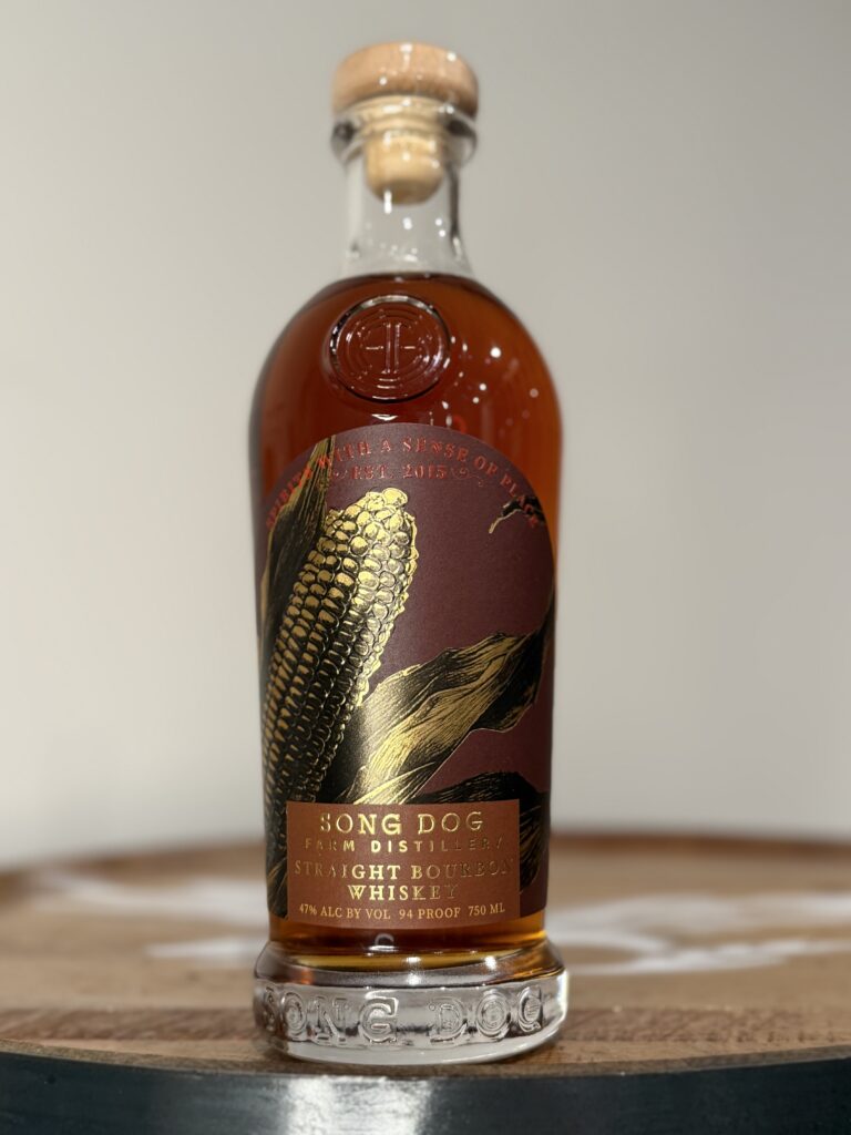 Song Dog Bourbon bottle sitting on whiskey barrel