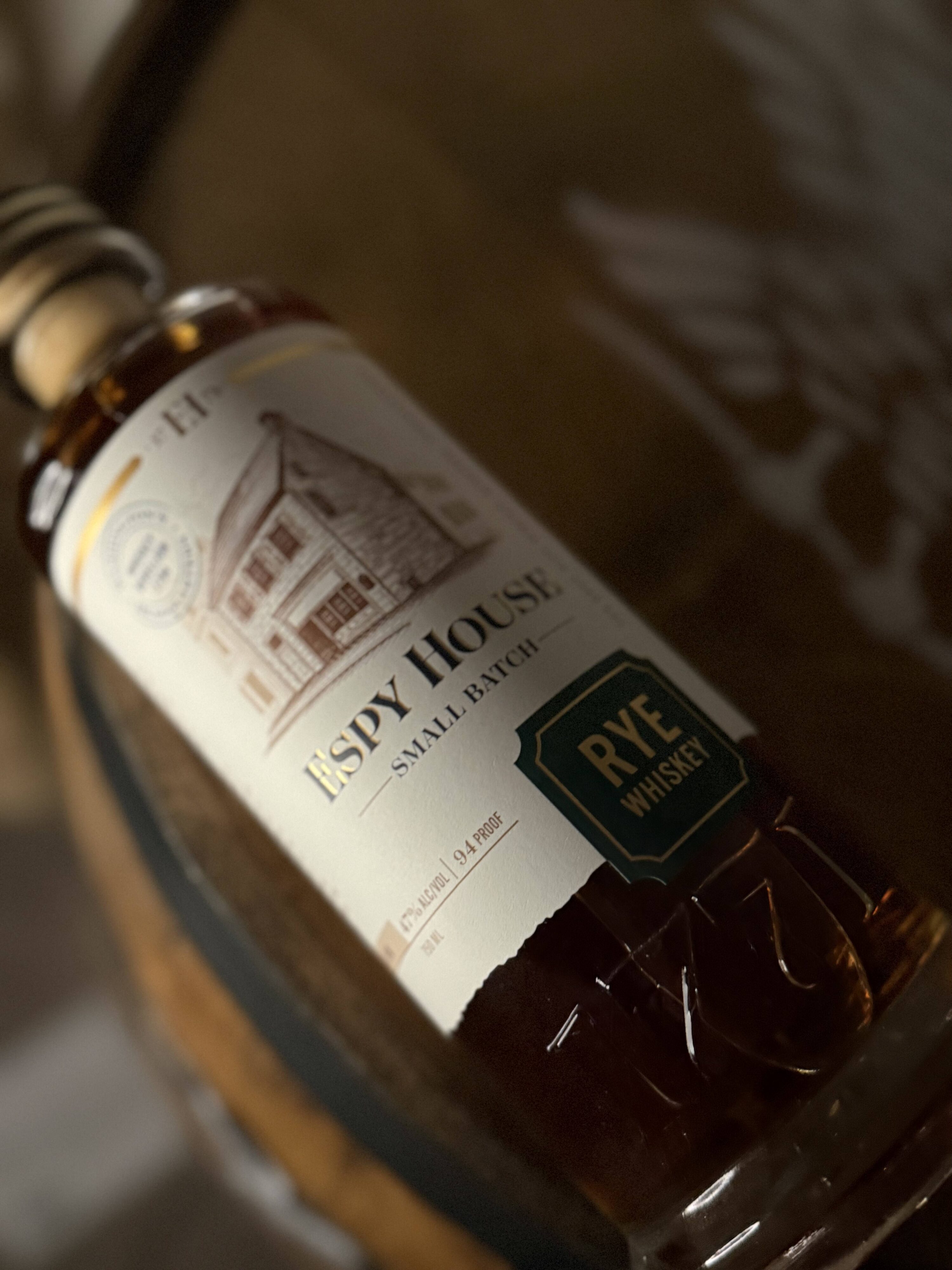 Espy House Rye lying on whiskey barrel head.