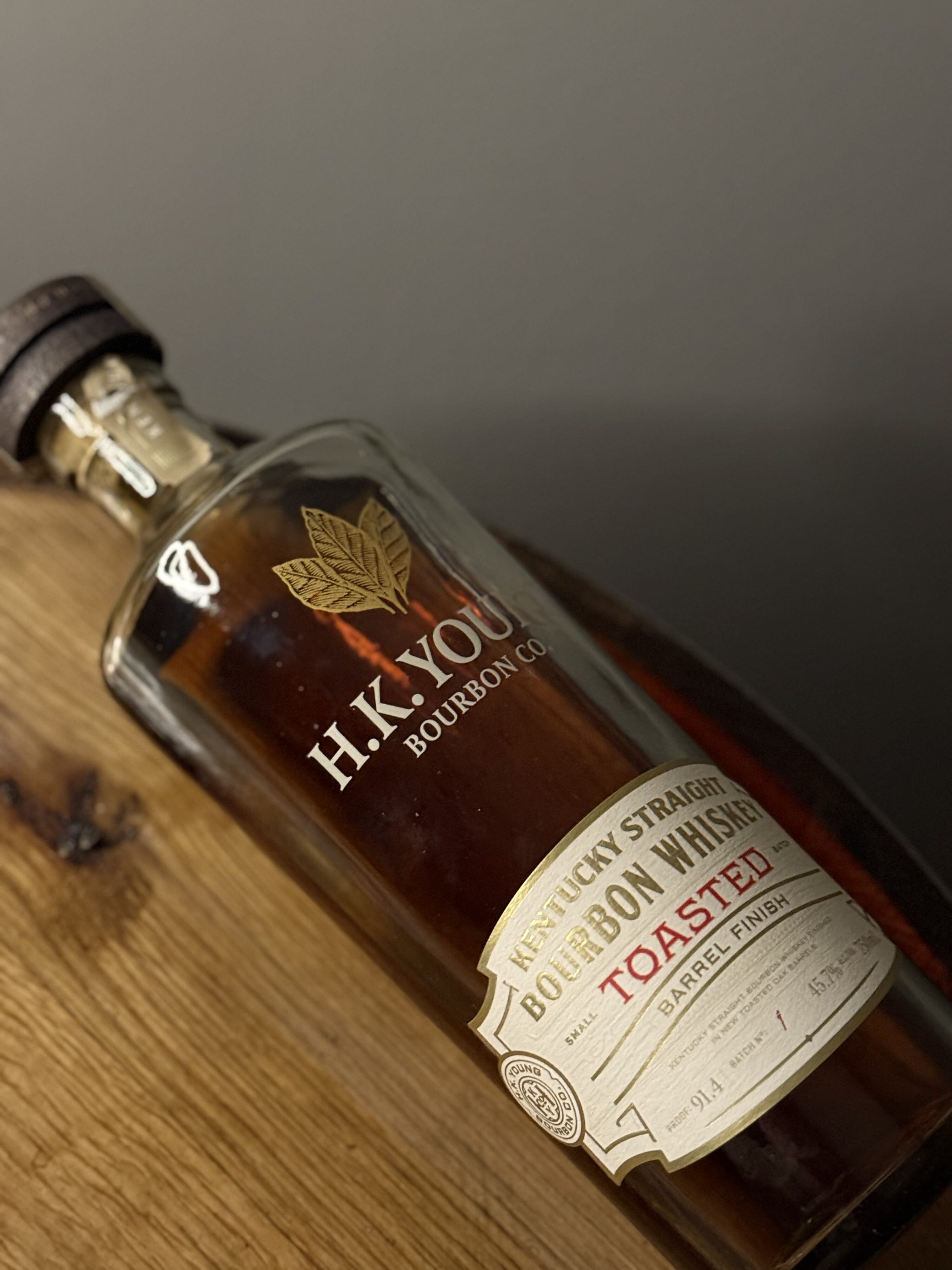 H.K. Young Toasted Small Batch Bourbon lying on whiskey barrel head