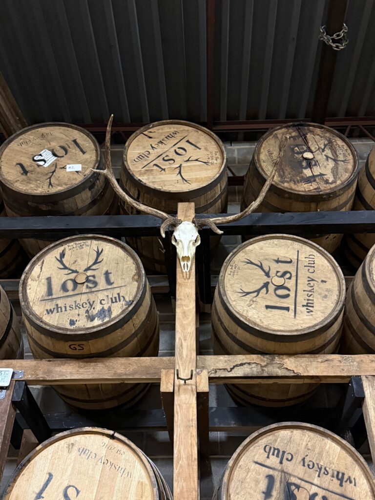 Lost Whiskey Club rickhouse whiskey barrels and antlers