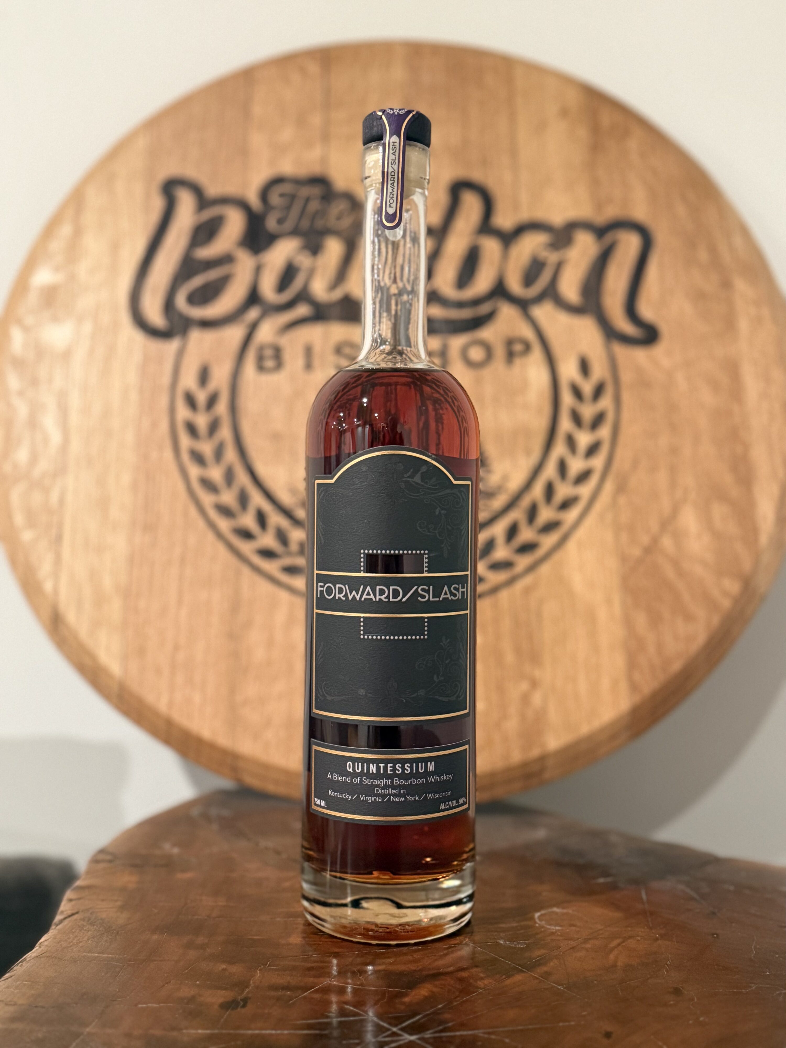 Forward Slash Quintessium in front of The Bourbon Bishop barrel head
