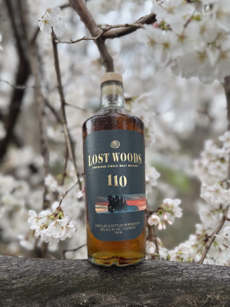 Lost Woods 110 Proof (Cask Strength) on branch with white cherry blossoms