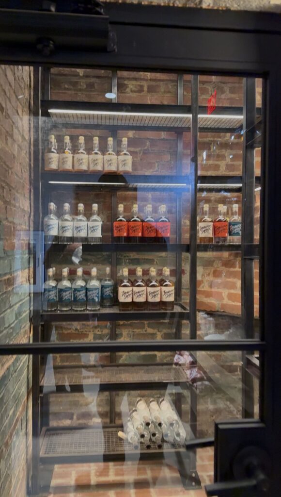 Rum bottles behind glass in old chimney/furnace room