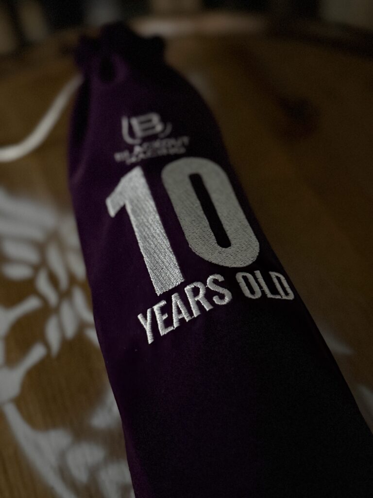 Blackout 10 Year Cask Strength Single Barrel Rye in premium, purple age stamped bag on whiskey barrel