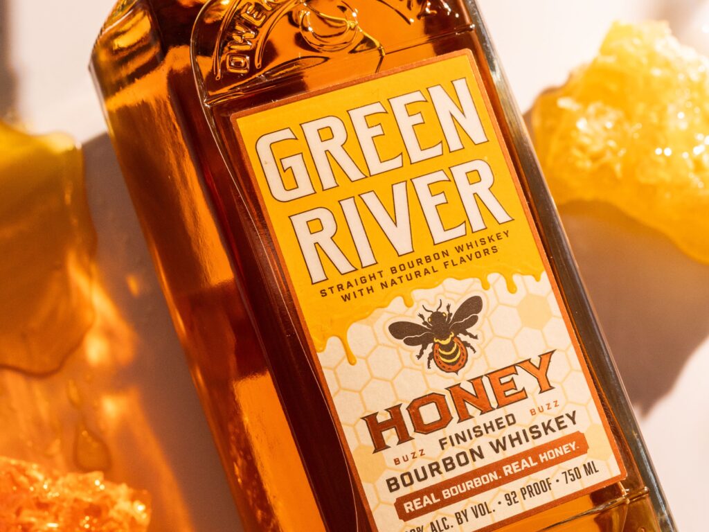 Green River Honey Bourbon close-up shot with honeycomb beside it