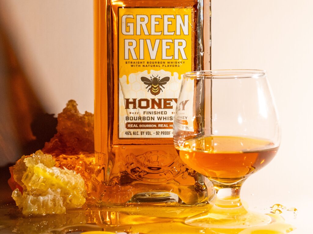 Green River Honey Bourbon close shot of honey comb, pooled honey and whiskey in tasting glass