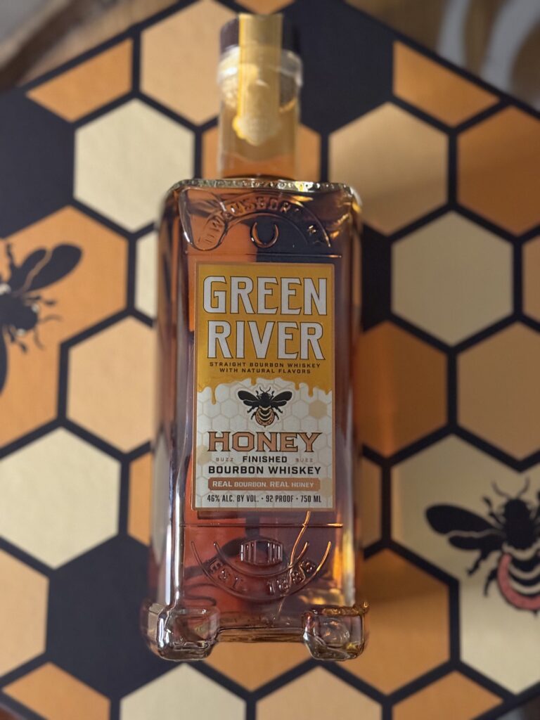 Green River Honey Bourbon lying on honeycomb box