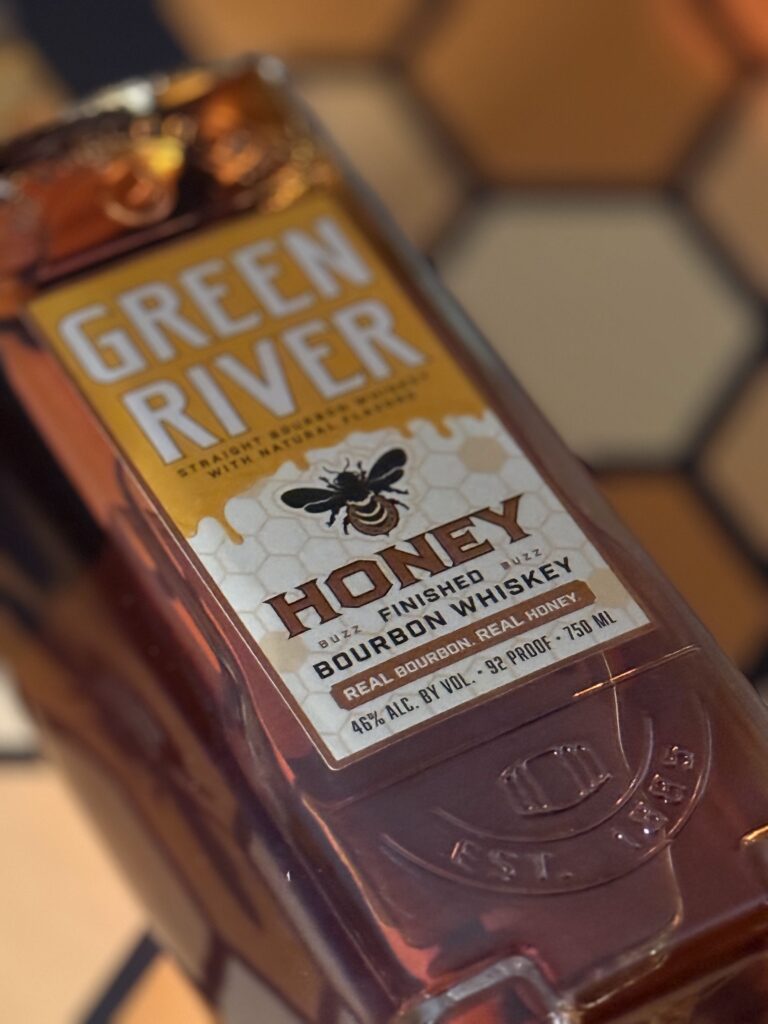Green River Honey Bourbon close up lying on honeycomb box