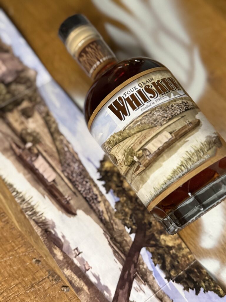 VA 250th Trio Four Grain Whiskey lying beside pullout artwork