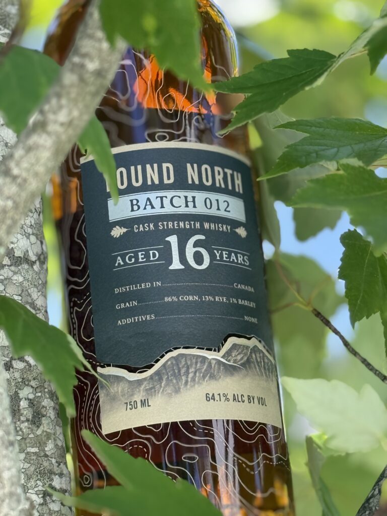 Found North Cask Strength Batch 012 amongst green tree leaves (close)