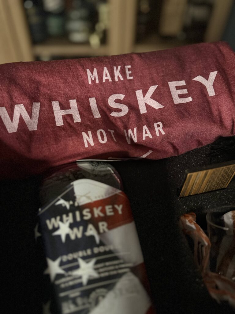 High Banks Whiskey War Double Double Oak 250th Anniversary Release blurred with "Make whiskey not war" slogan High Banks shirt