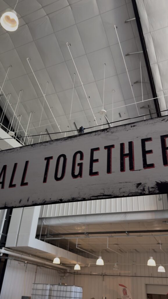 MurLarkey's motto "All Together Now" highlights the community, family centered, experiential focused aspect of the company. The sign hangs above the entryway into the distillation and tasting room
