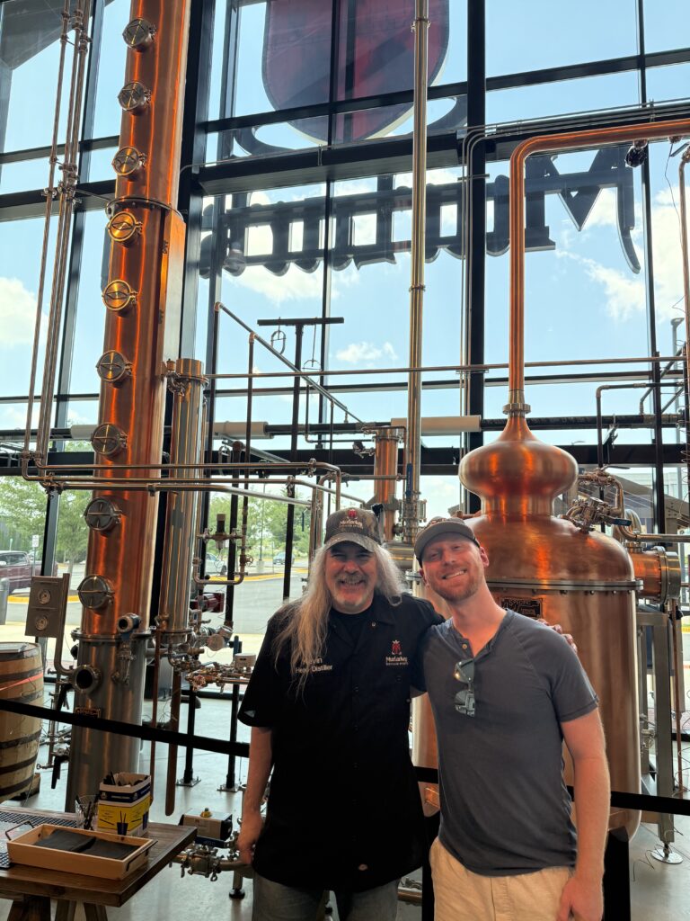 MurLarkey head distiller Kevin Szady and author Ethan Pope pose in front of the company's brand new 35 ft column still