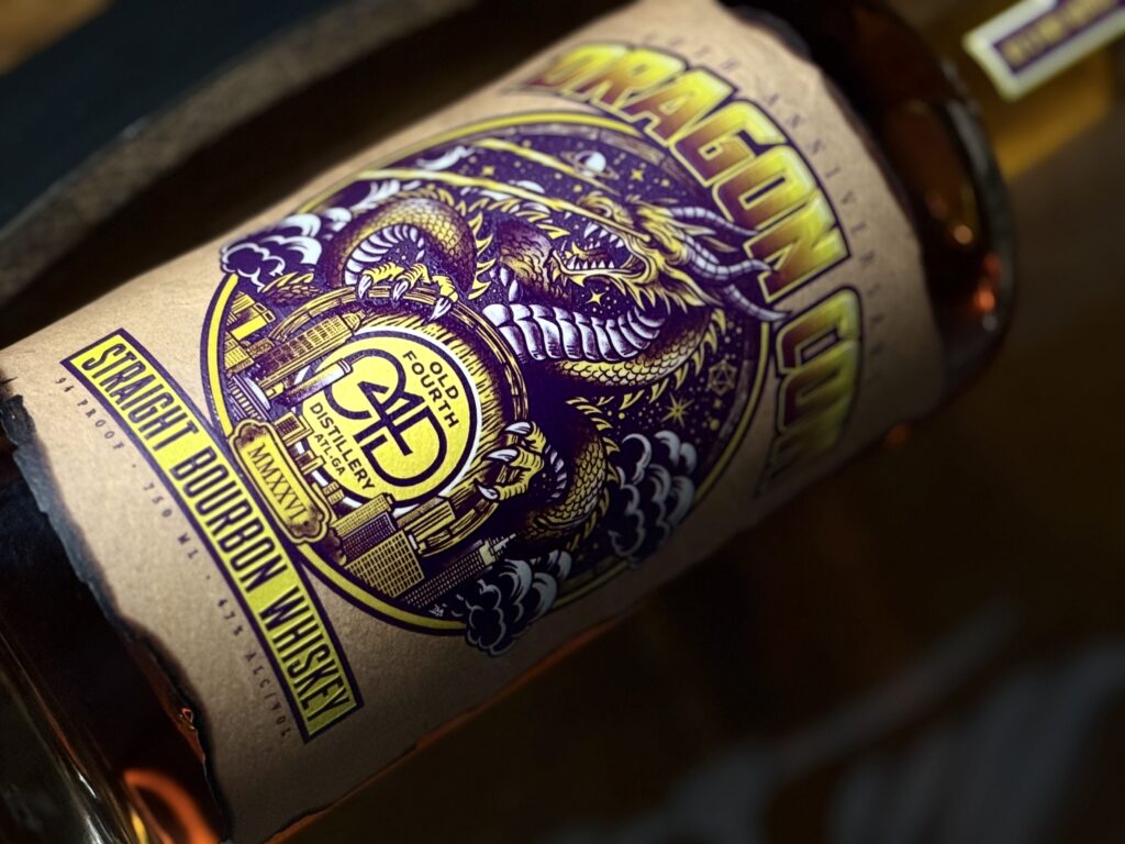 Old Fourth DragonCon 40th Anniversary Bourbon lies on whiskey barrel