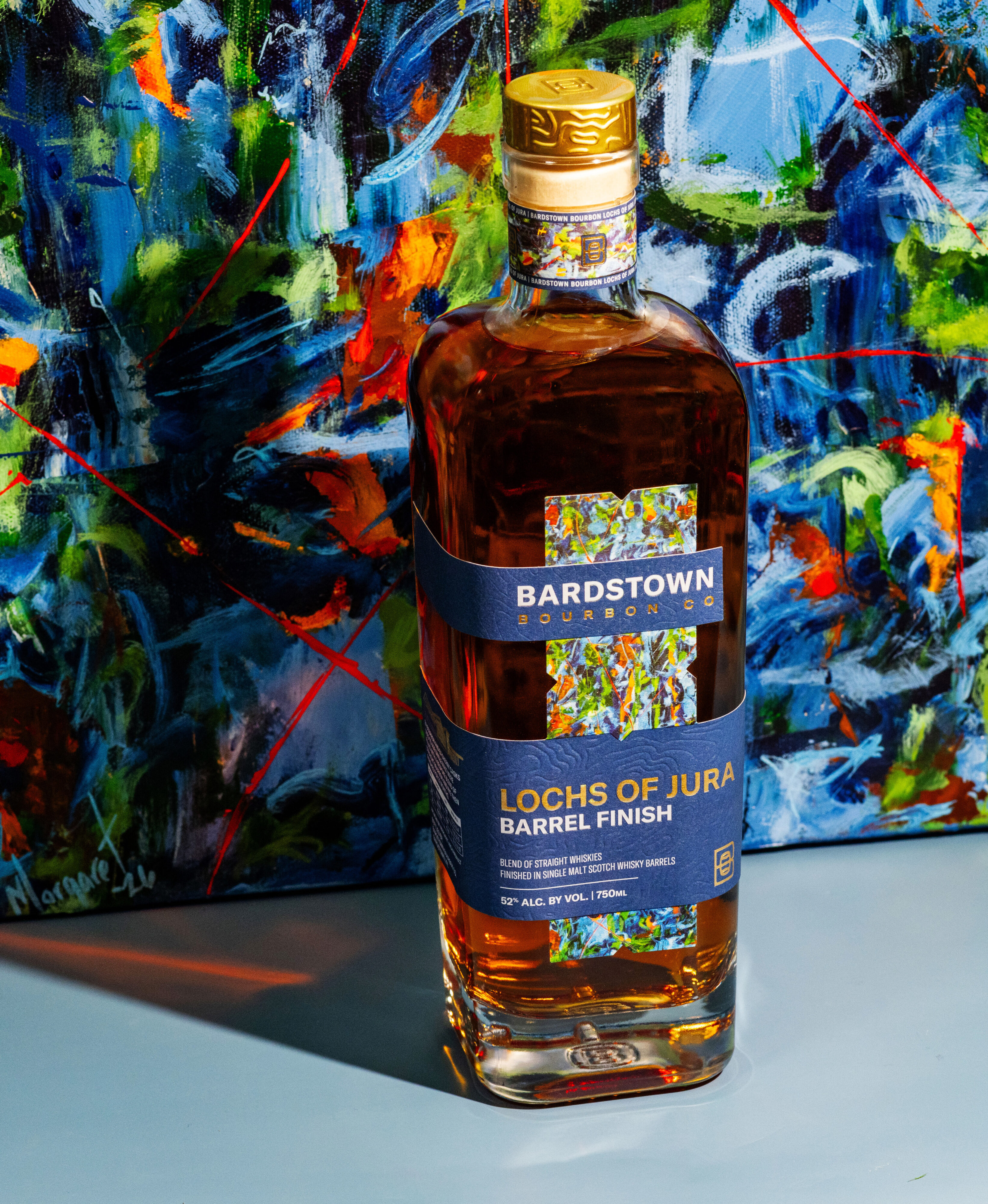 Bardstown Bourbon Company Lochs of Jura stands against its full-size custom artwork by Louisville artist Margaret Archambault