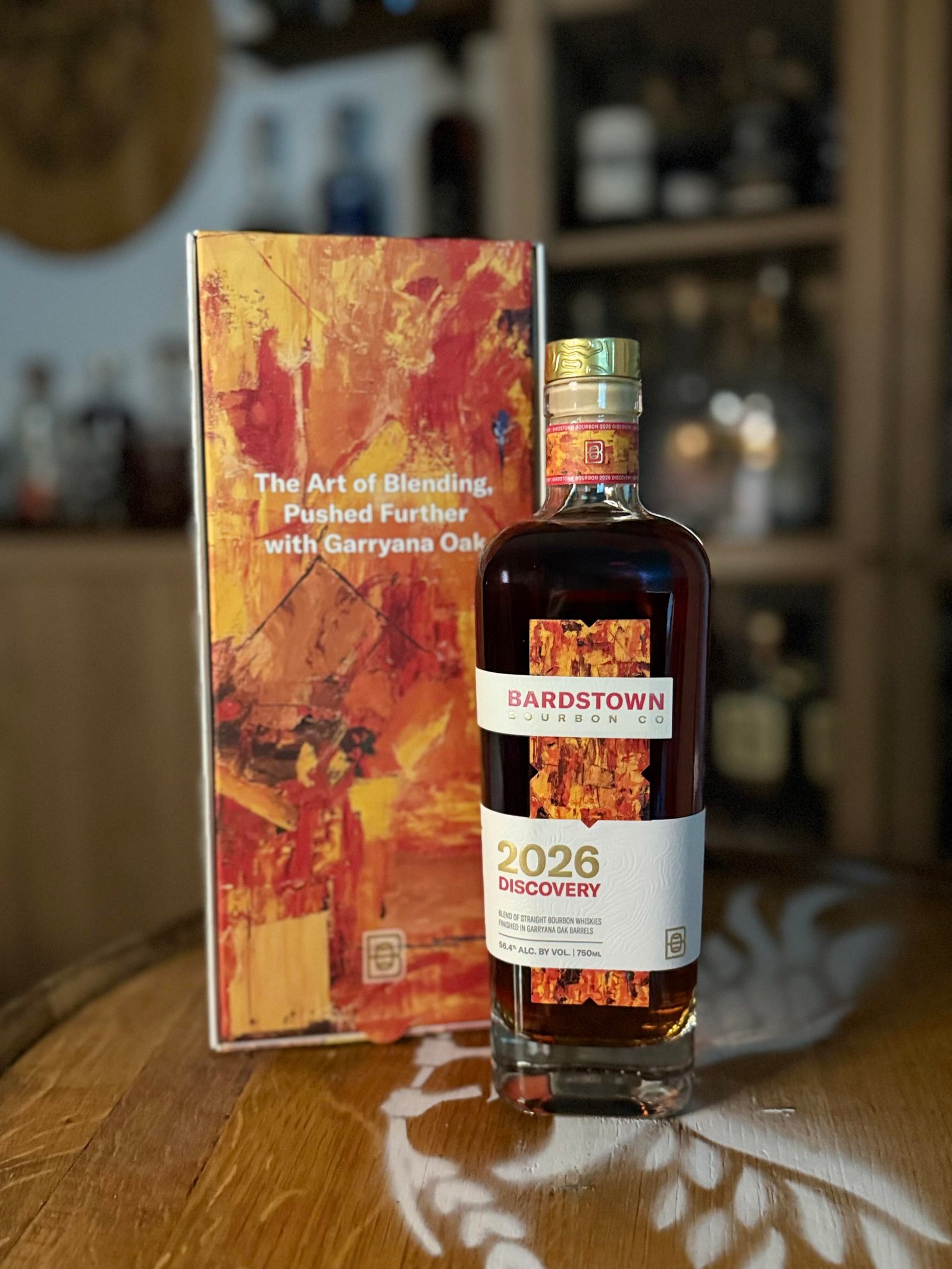 Bardstown Bourbon Company's Discovery 2026 stands on whiskey barrel beside art box