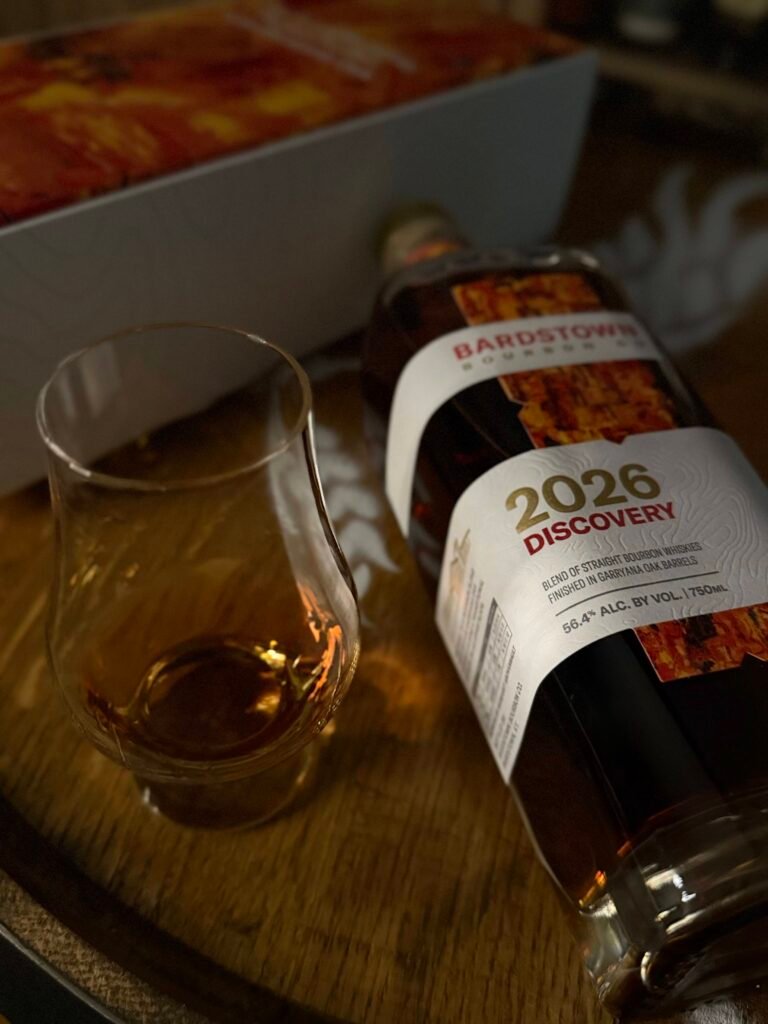 Bardstown Bourbon Company's Discovery 2026 lies beside art box and full glencairn