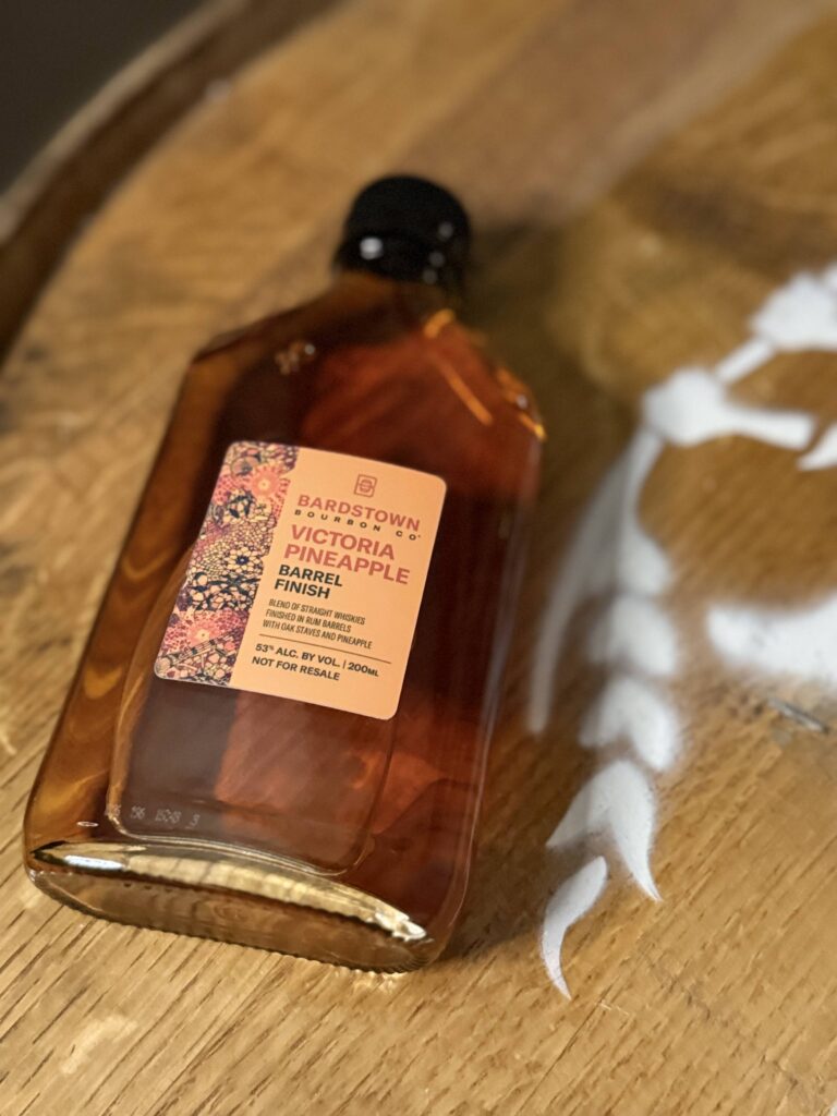 Bardstown Bourbon Company Victoria Pineapple sample lying on whiskey barrel