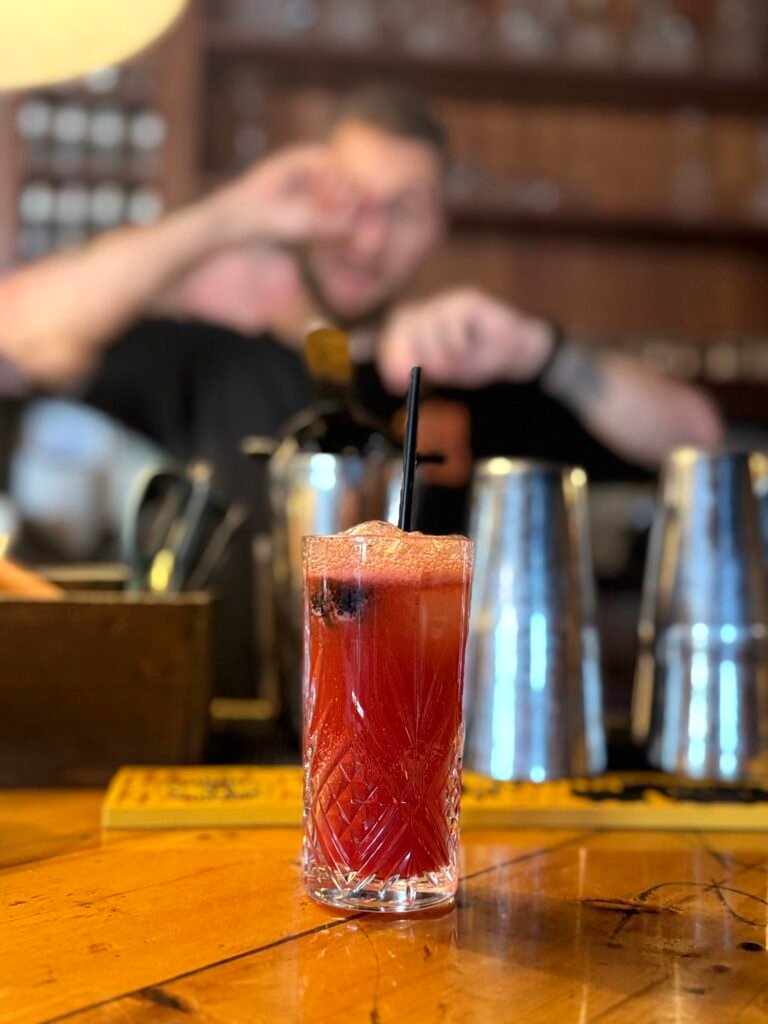 Finished blackberry whiskey cocktail sits on Ironclad's main bar
