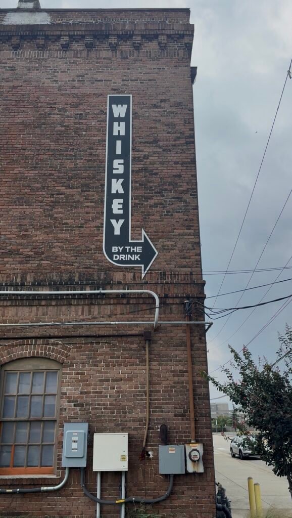 A sign on the side of Ironclad's historic brick building points the way to quality Virginia spirits