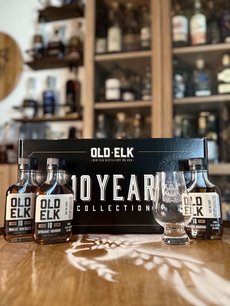 Old Elk 10-Year Collection box with 3 sample bottles and glencairn on whiskey barrel