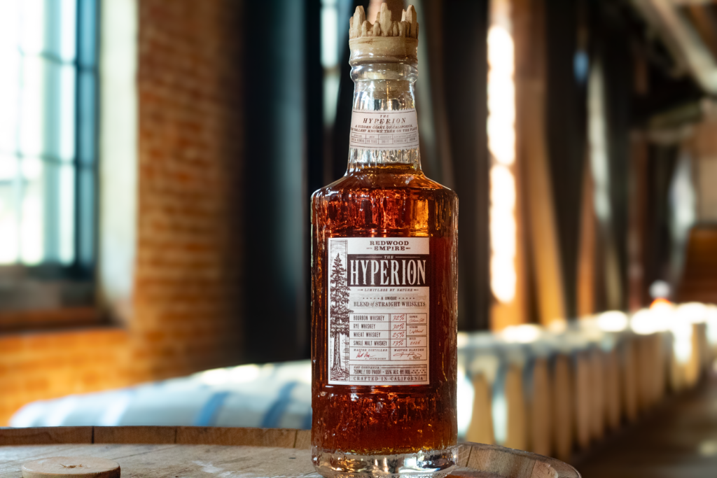 Redwood Empire's newest release "The Hyperion" in front of whiskey barrels and sun streaming through windows