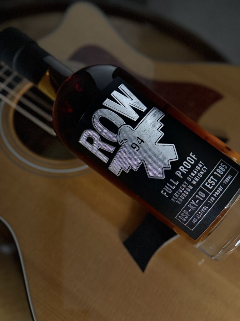 Row 94 Full Proof lying on guitar