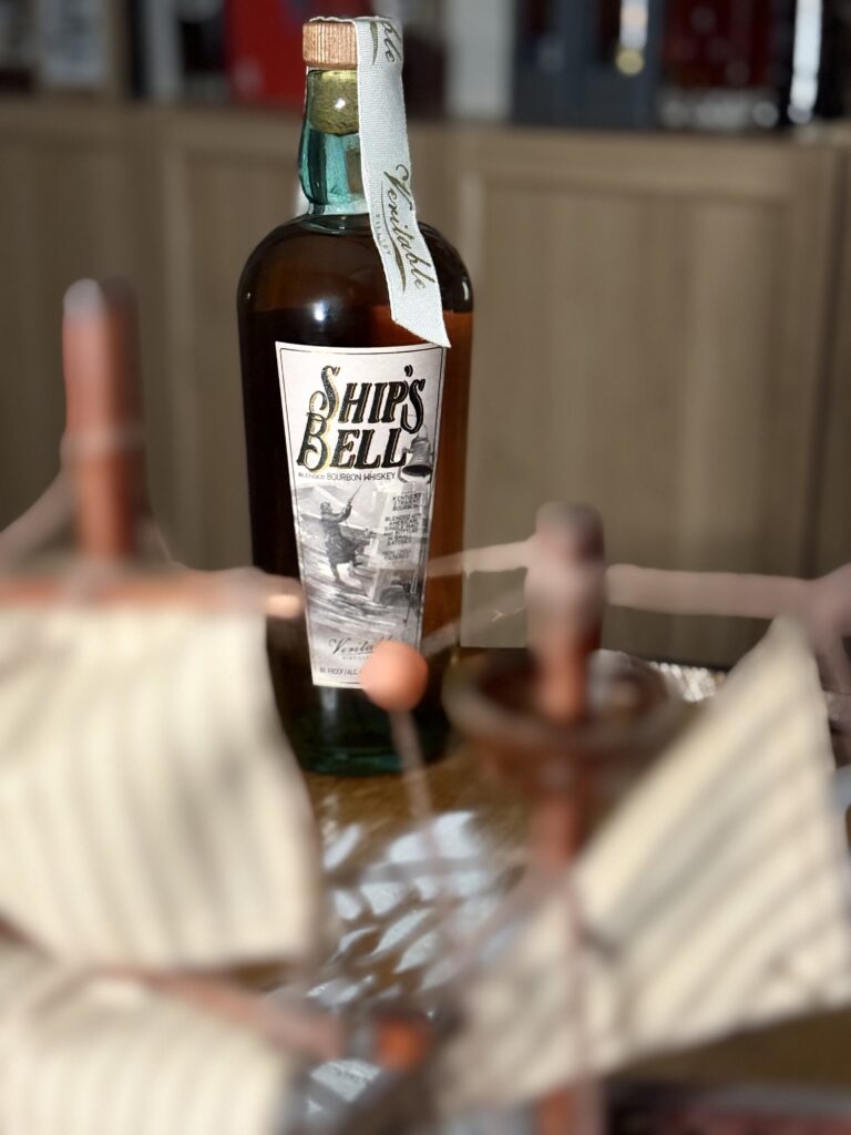 Veritable "Ships Bell" blended bourbon seen through blurred ship mast