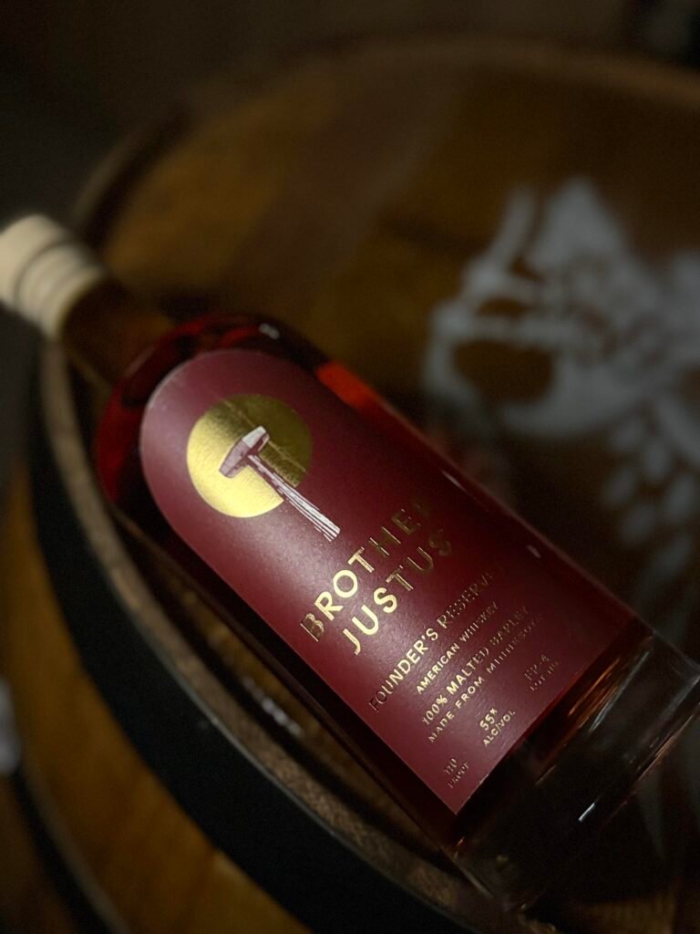 Brother Justus' Founder's Reserve IV lying at angle on darkened whiskey barrel head