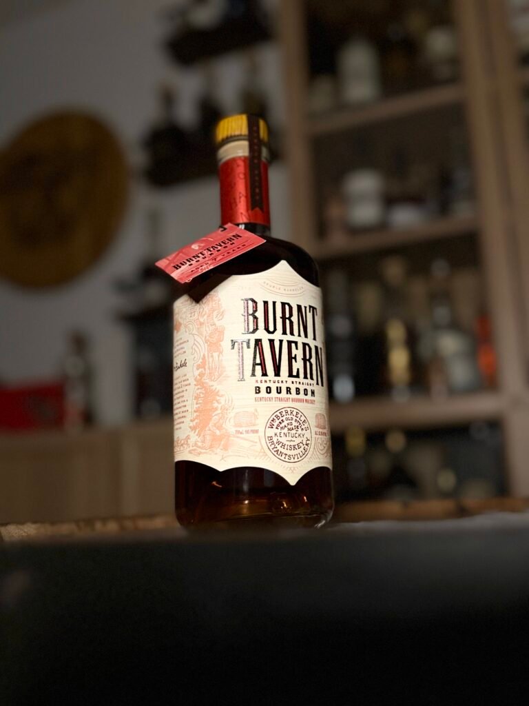 Burnt Tavern Double-Barreled bourbon shot from below as it sits on whiskey barrel