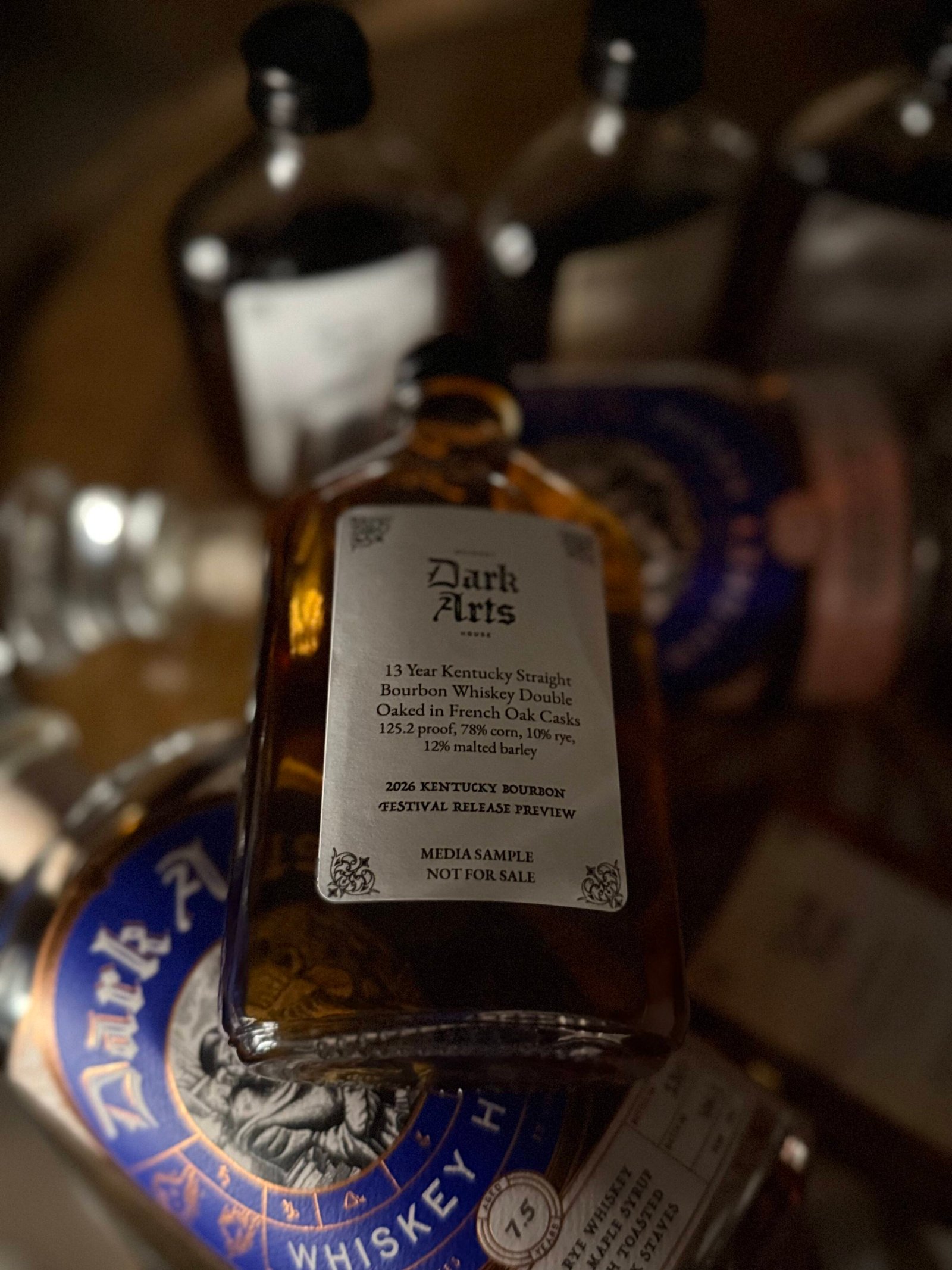 Dark Arts KBF Special Release: 13 Year Kentucky Bourbon French Oaked lying on past blue label releases.