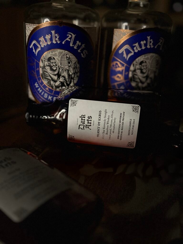 Dark Arts KBF Special Release: "Flight of Icarus" 11.5 Year Hazmat Kentucky Bourbon lies in front of past blue label releases