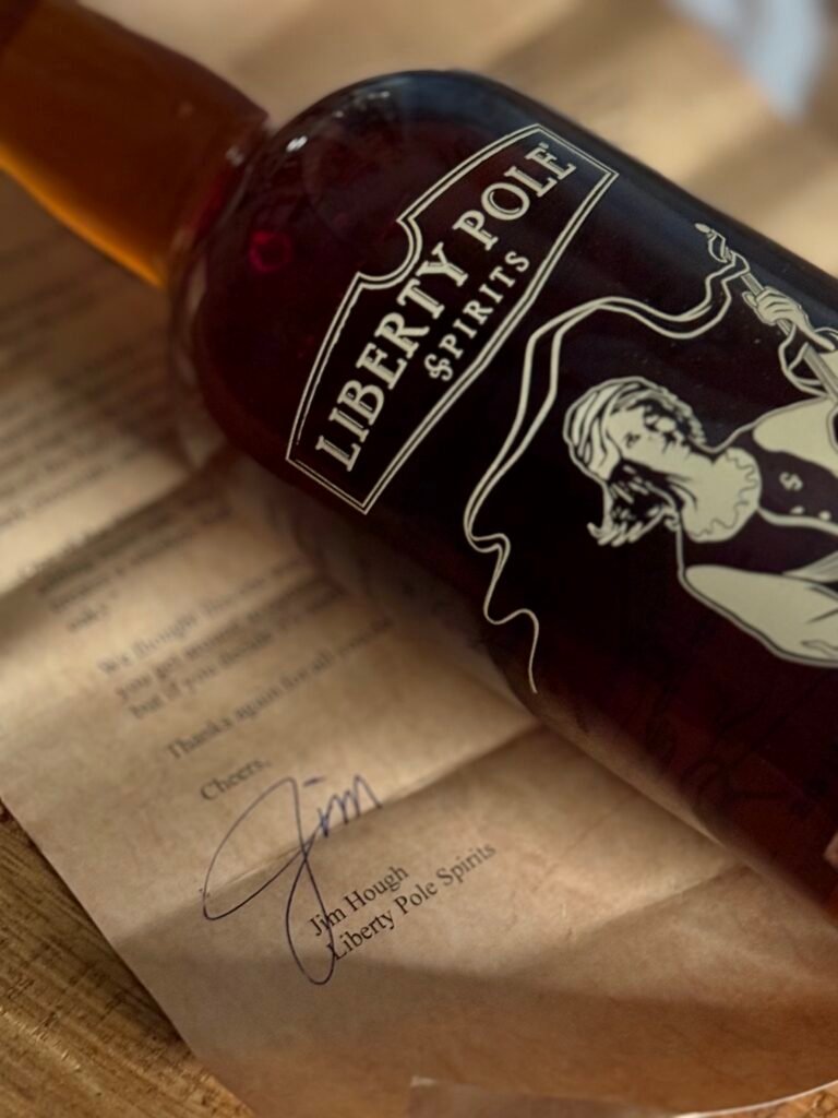 Liberty Pole Double Oaked High Rye Bourbon lying on close-up of vintage looking letter from owner Jim Hough