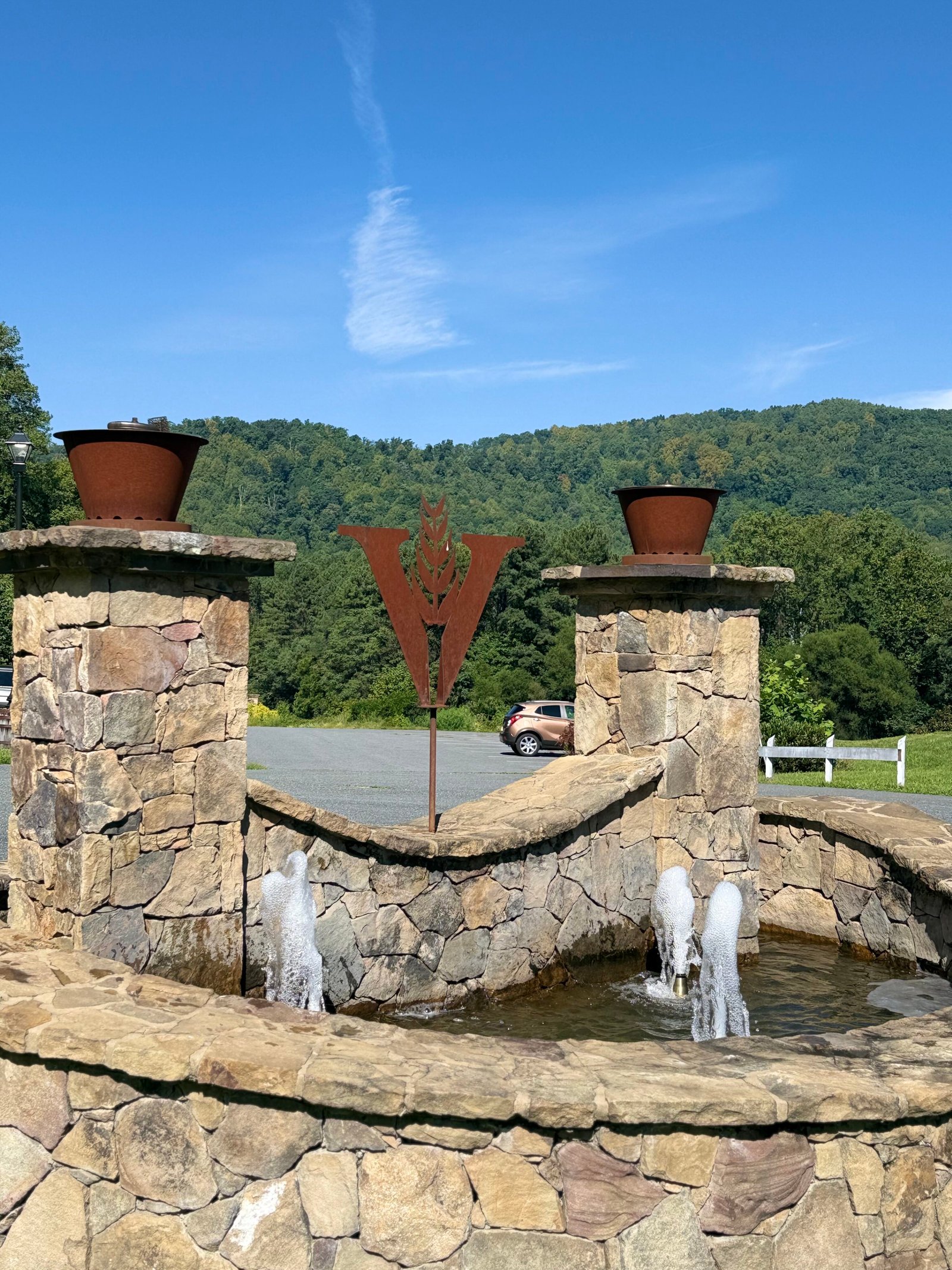 VDC logo fountain out front of tasting room showing the mountains surrounding the campus