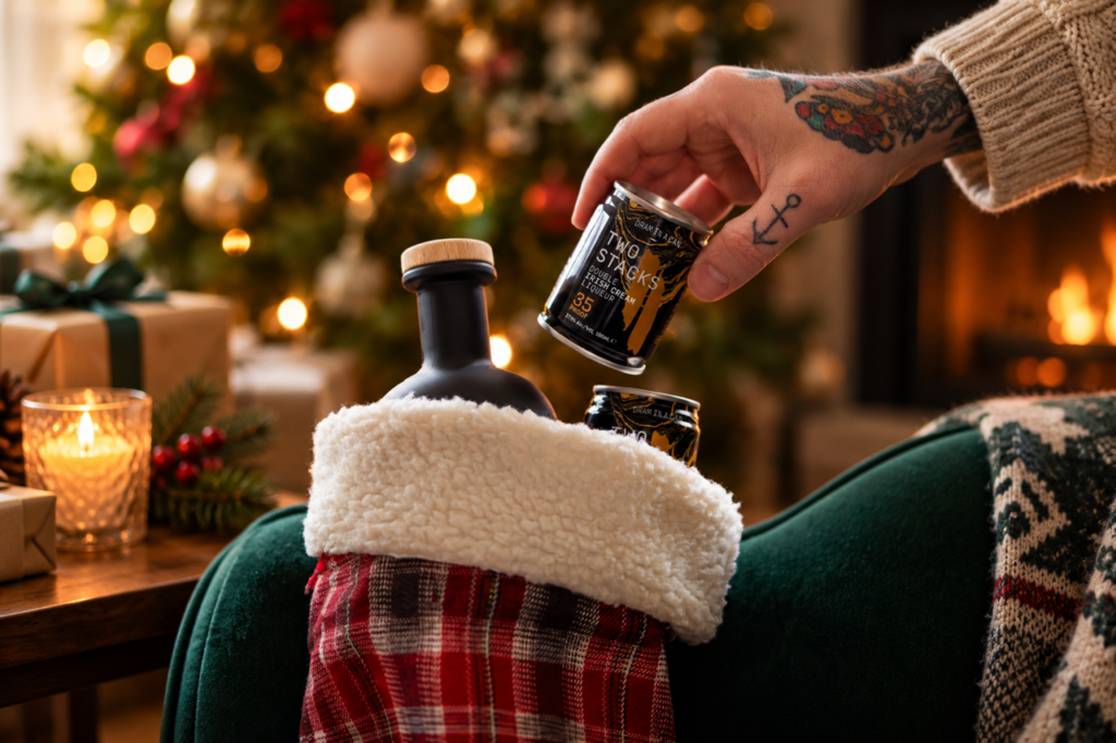 Two Stacks Double Irish Cream Liqueur Dram in a Can is placed by a tattoed hand into a holiday stocking