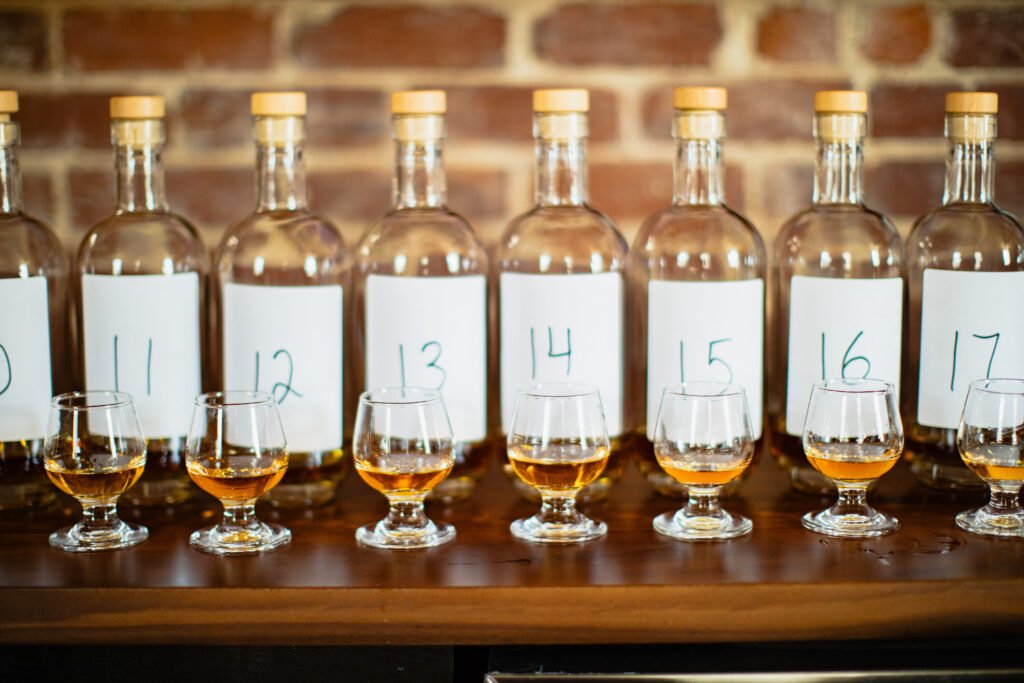 Multiple sample numbered blend sample bottles sit in front of tasting glasses