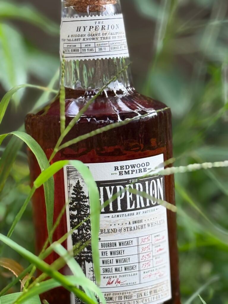 Close-up of Redwood Empire The Hyperion whiskey seen through blades of grass