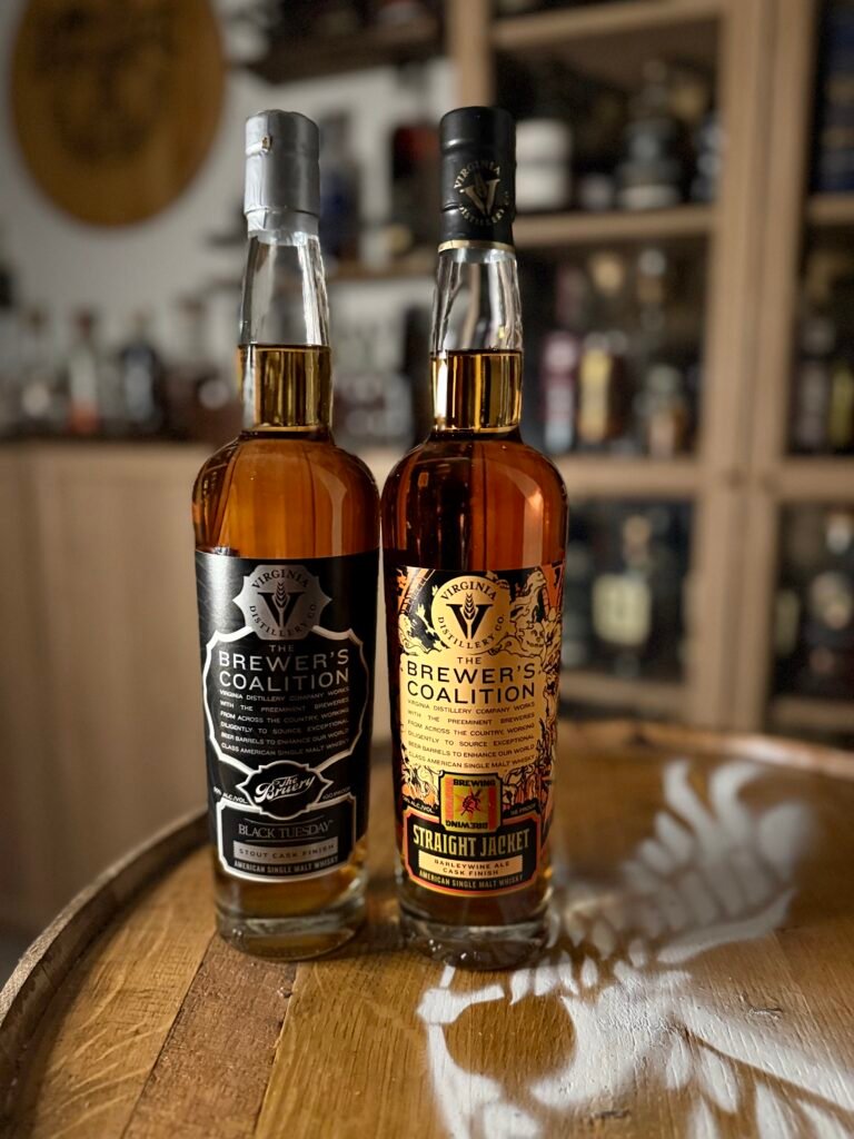 The duo release of Virginia Distillery Co's newest Brewer's Coalition releases: The Bruery "Black Tuesday" stout finished and Revolution Brewing Barleywine finished american single stand together in front of collection
